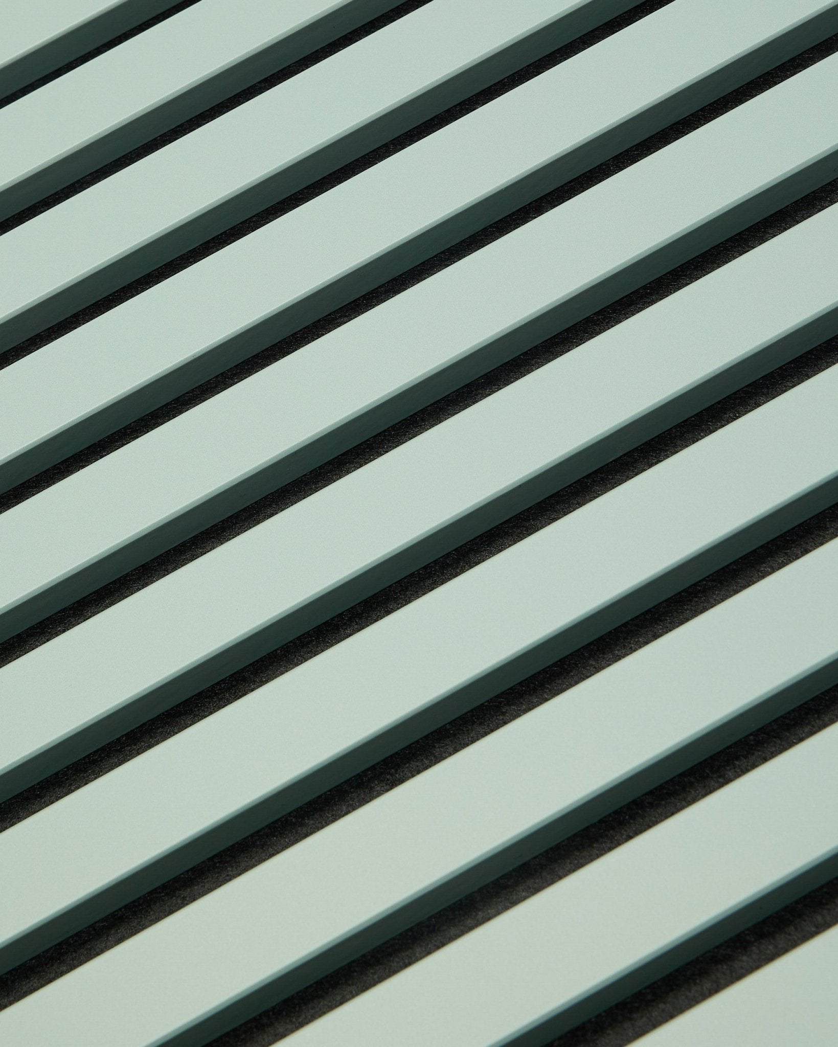 Hue | Akupanel / Cloud de WoodUpp présente des panneaux acoustiques en bois vert clair avec des lattes vertical et des interstices foncés, formant un motif géométrique pensé pour l’absorption acoustique.
