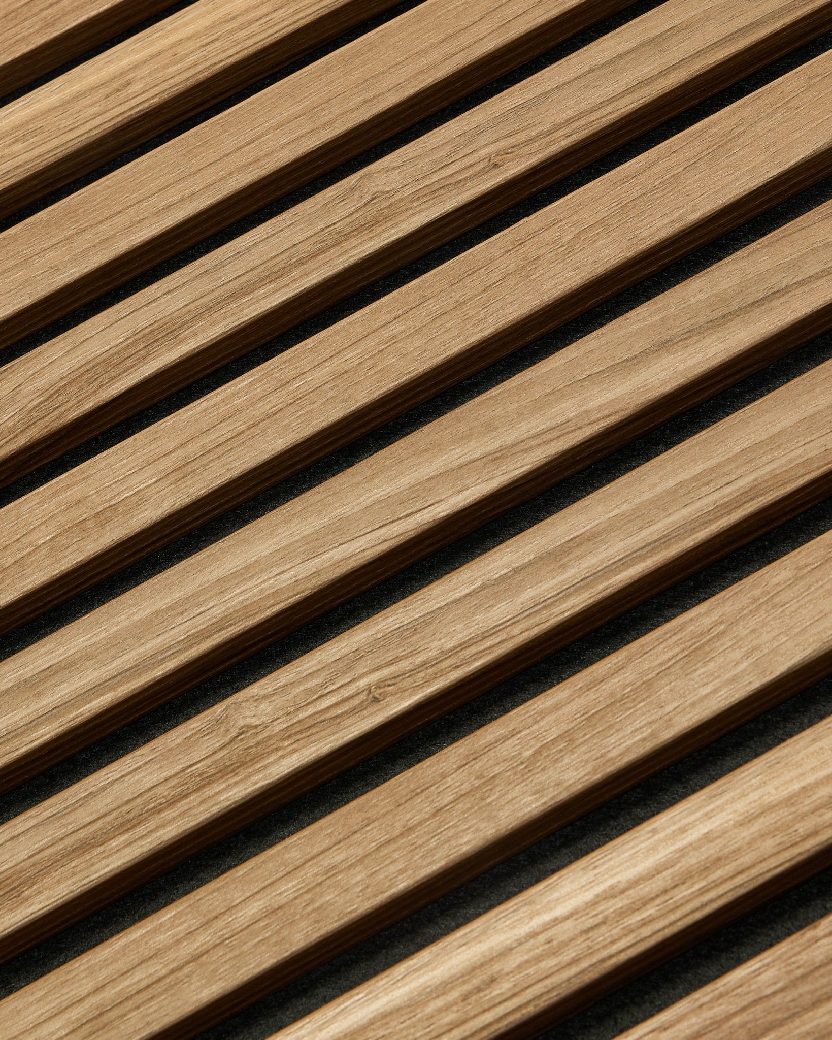 Gros plan en diagonale du WoodUpp Akupanel Essential Panneau acoustique en English Walnut, 240x60 cm, montrant une finition uniforme et un fond sombre entre chaque latte de bois.