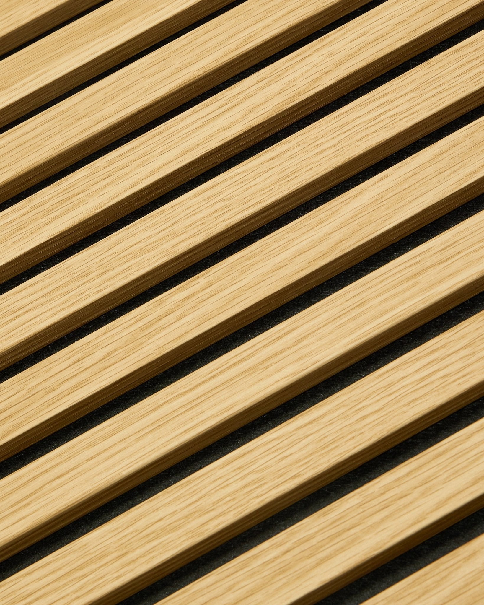 Gros plan sur le Panneau acoustique WoodUpp Akupanel en chêne Southern Oak, 240 x 60 cm, avec des lattes diagonales et des interstices acoustiques foncés pour une absorption sonore renforcée.