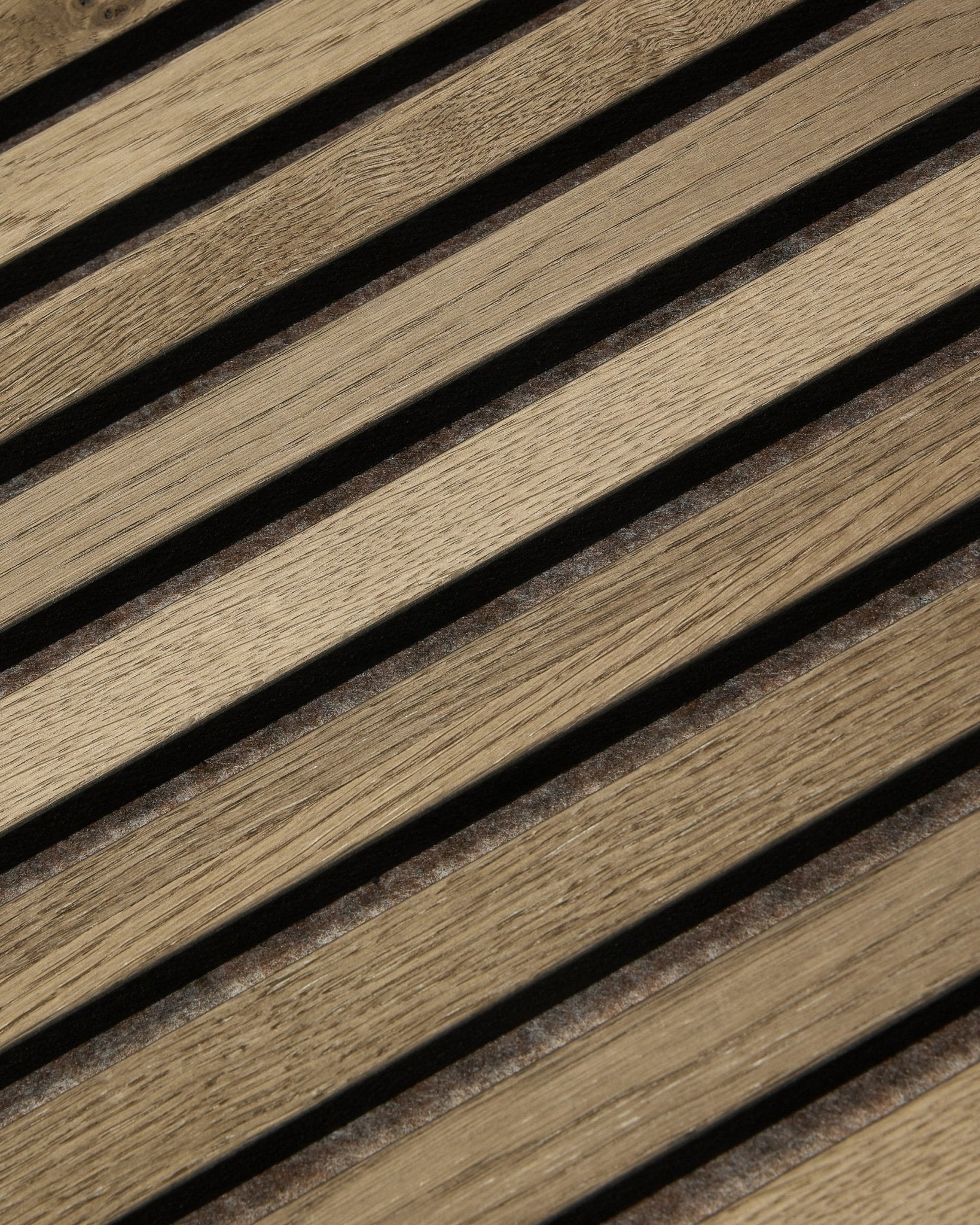 Gros plan sur le Panneau acoustique WoodUpp Tonal Akupanel en Grey Oak (240x60 cm), montrant des lattes diagonales régulièrement espacées avec un veinage natural oak et un design nordique.