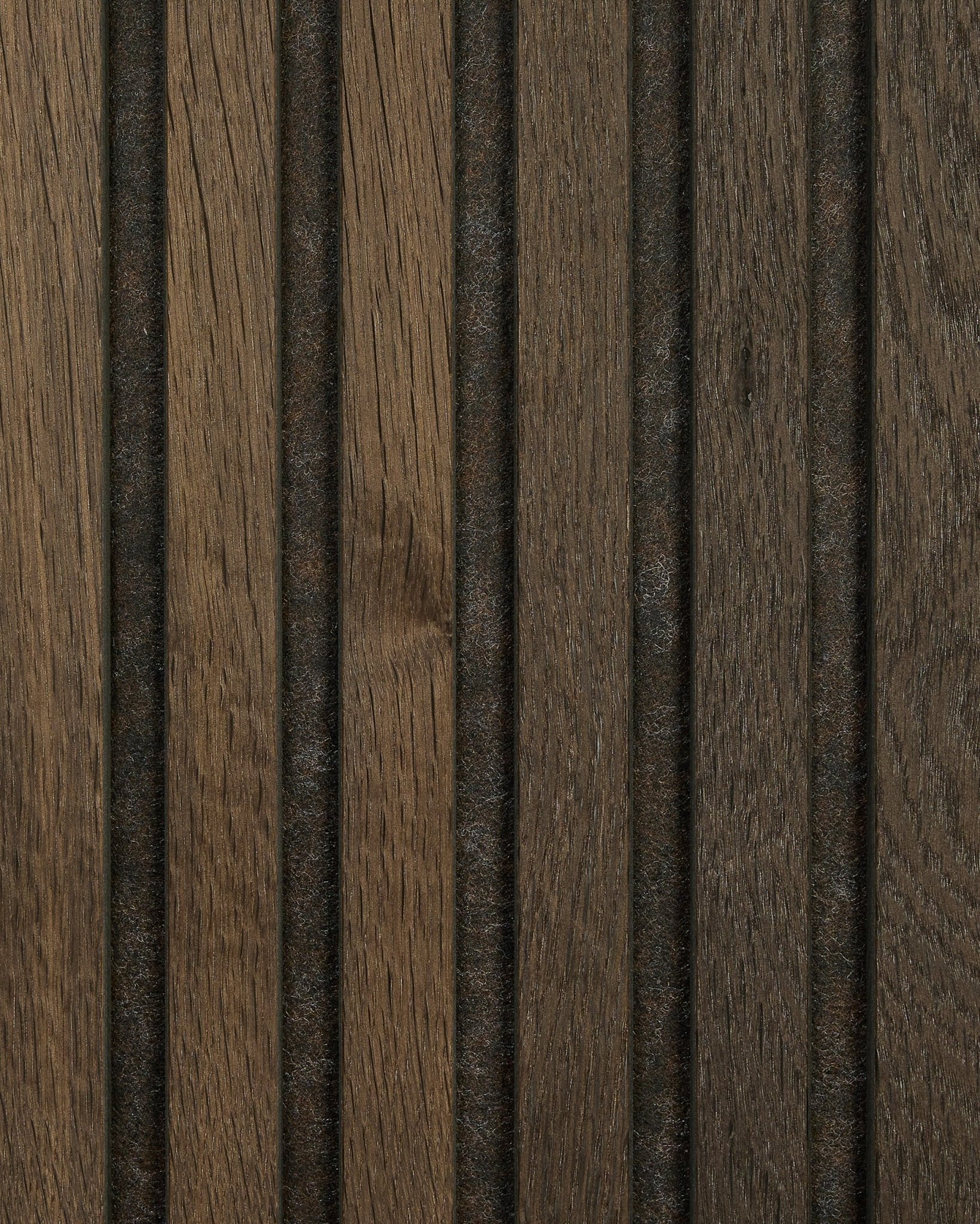 Gros plan sur un échantillon de panneau acoustique en bois Akupanel en Smoked Oak par WoodUpp, avec le veinage naturel du brown, des rainures vertical et des lignes sombres régulièrement espacées.