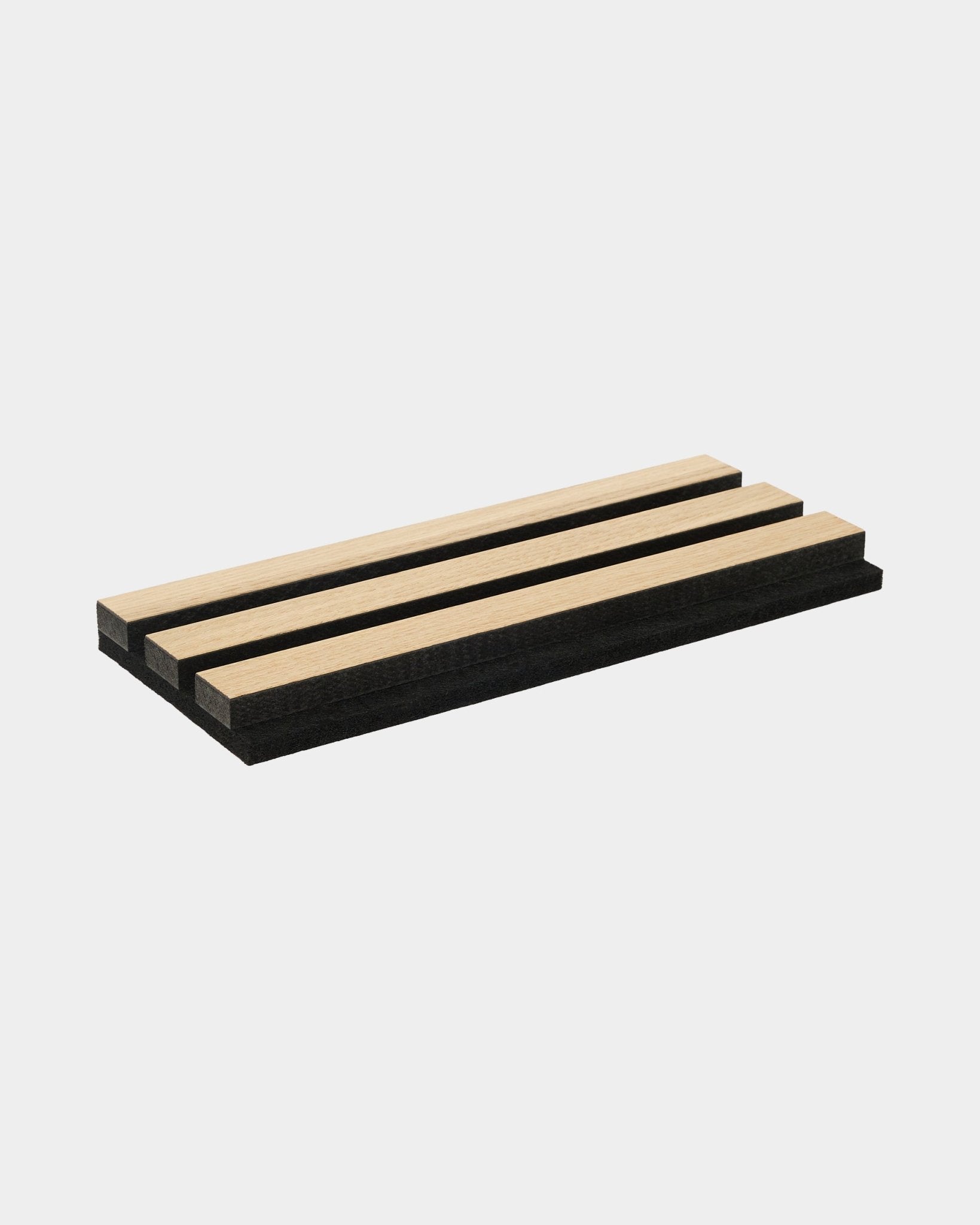 Plateau d’échantillons Akupanel présentant des lattes acoustiques en chêne classique et en MDF black avec support en feutre black, disposées sur un fond blanc uni.