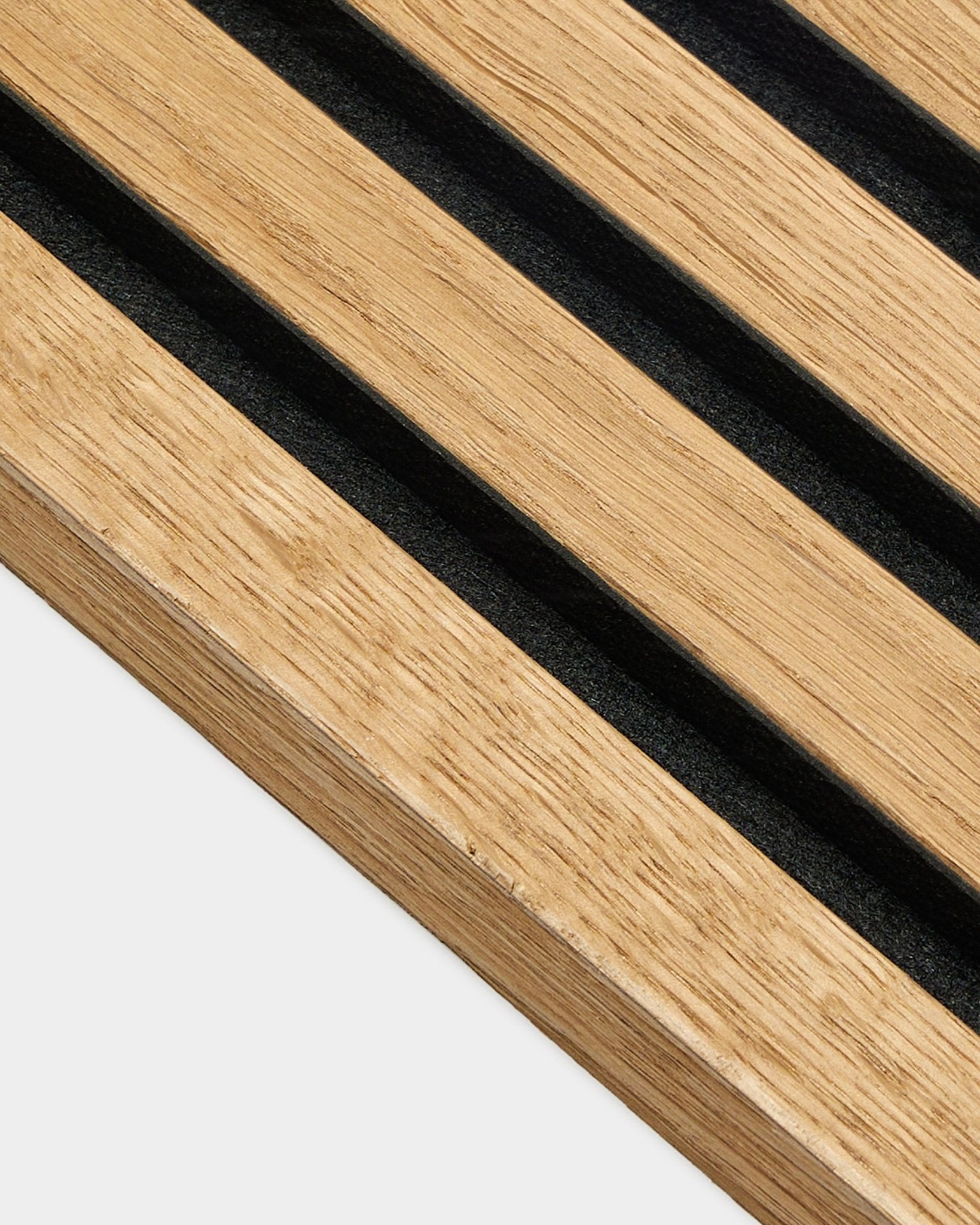 Gros plan sur un panneau avec lamelle de finition WoodUpp en chêne Rustic Brown (2,2 cm), conçu pour les installations acoustiques Akupanel, avec des lattes régulièrement espacées sur un mur clair.