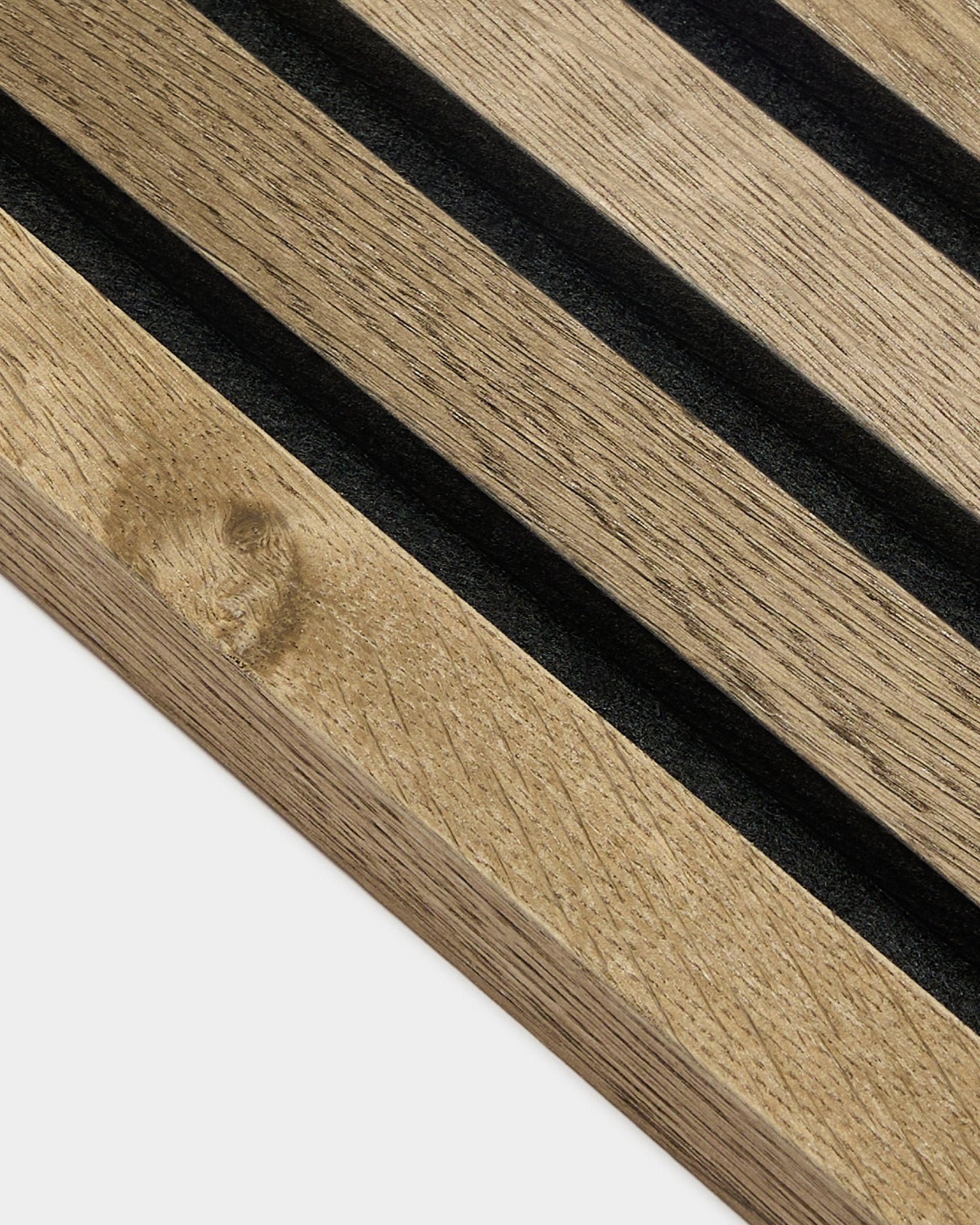 Gros plan sur la lamelle de finition WoodUpp Akupanel en Rustic Grey Oak, Panneau acoustique en MDF de 2,2 cm avec rainures black et veinage du bois visible sur fond gris clair.