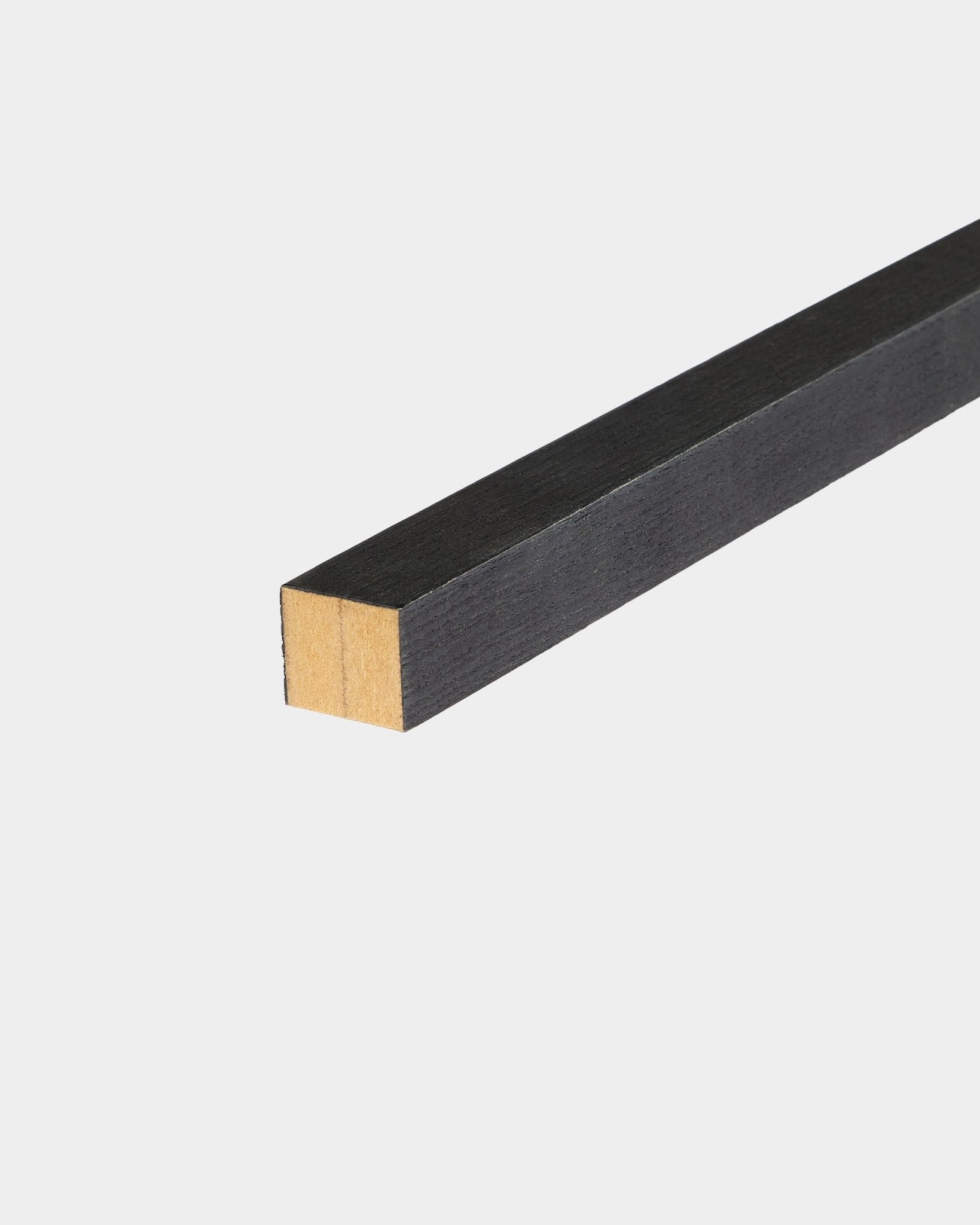 Lamelle d’extrémité WoodUpp Black Frêne, 2,2 cm, conçue pour une installation Akupanel Panneau acoustique, posée sur une surface blanche avec une extrémité non finie.
