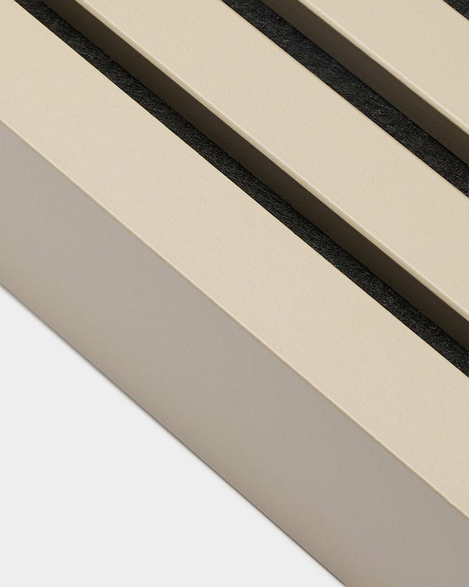 Gros plan sur WoodUpp End Lamella en finition Stone, largeur 6,7 cm — accessoire d’installation pour cadres en MDF ou panneaux acoustiques Akupanel. Lattes de panneau Beige avec espaces black.