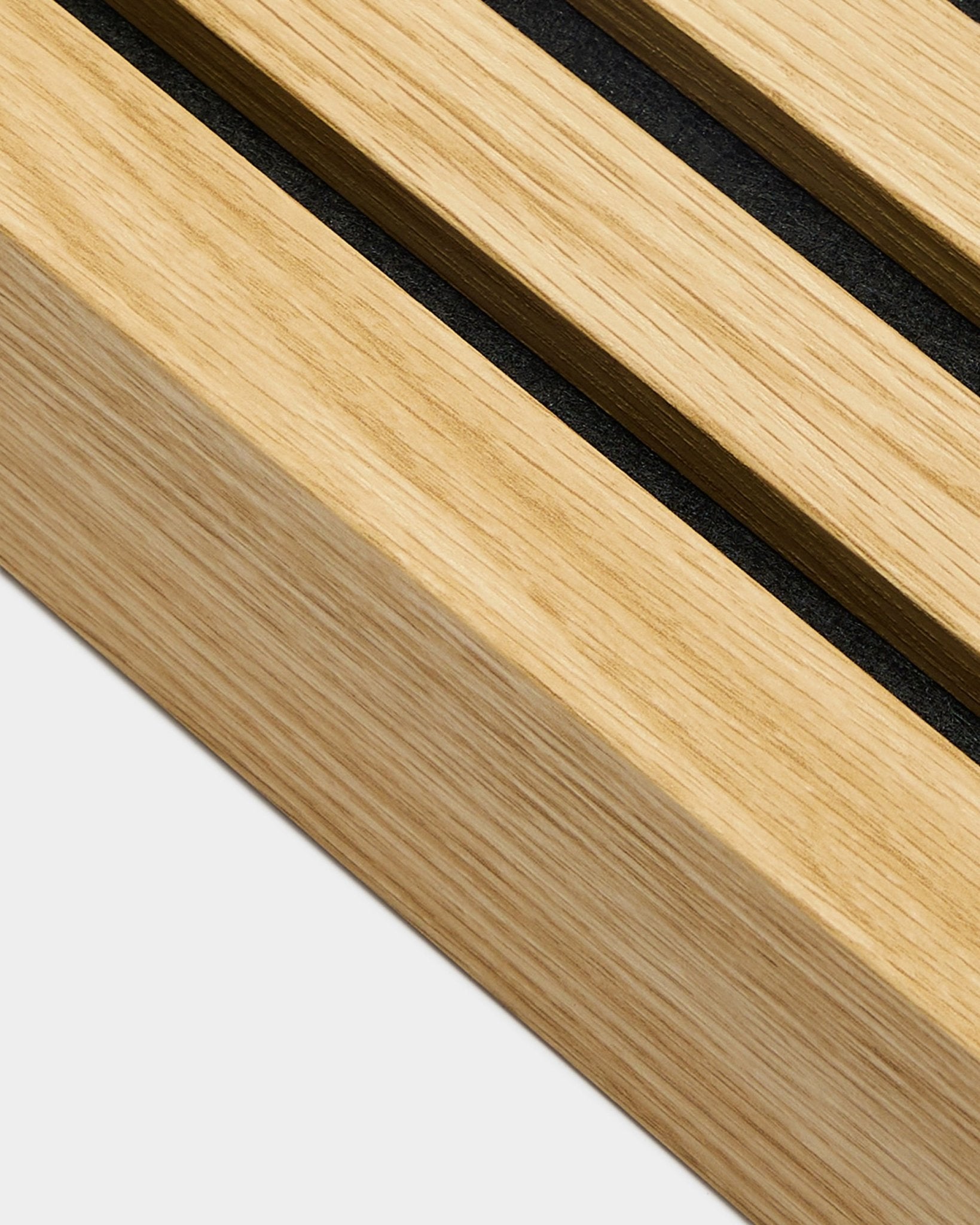 Gros plan sur le produit d’installation WoodUpp Akupanel, une lamelle d’extrémité en chêne Southern Oak de 6,7 cm de large, avec des rainures black dans le bois clair pour des lignes Panneau acoustique bien définies.