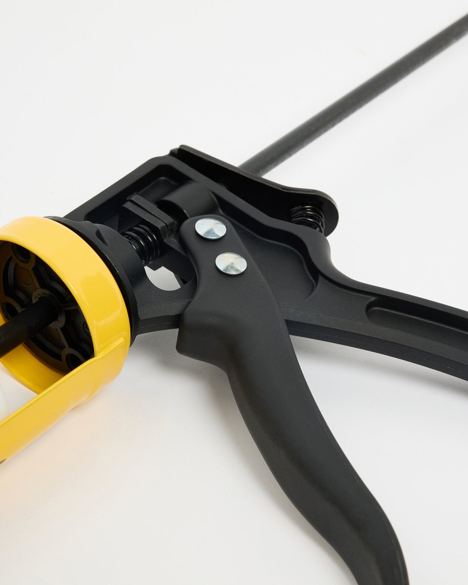 Gros plan sur le black WoodUpp et le pistolet à colle jaune (290 ml), un accessoire CREATE pour l’installation de Akupanel Panneau acoustique, présenté sur une surface blanche.