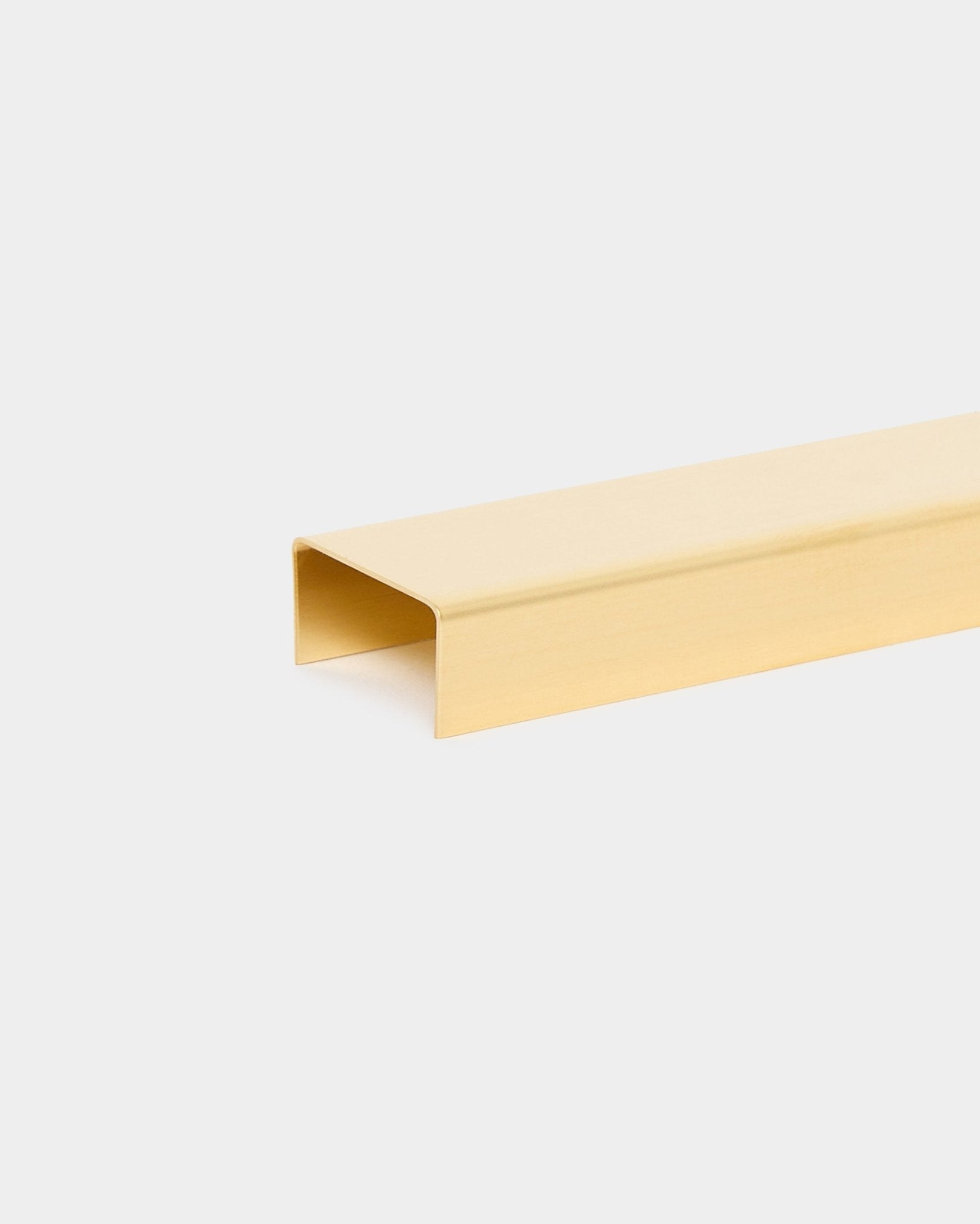 Le Liva | Cover / Brass, 120 cm de WoodUpp est un accessoire de finition métallique en U, dans une teinte dorée, pour panneaux acoustiques en bois, présenté sur un fond clair.