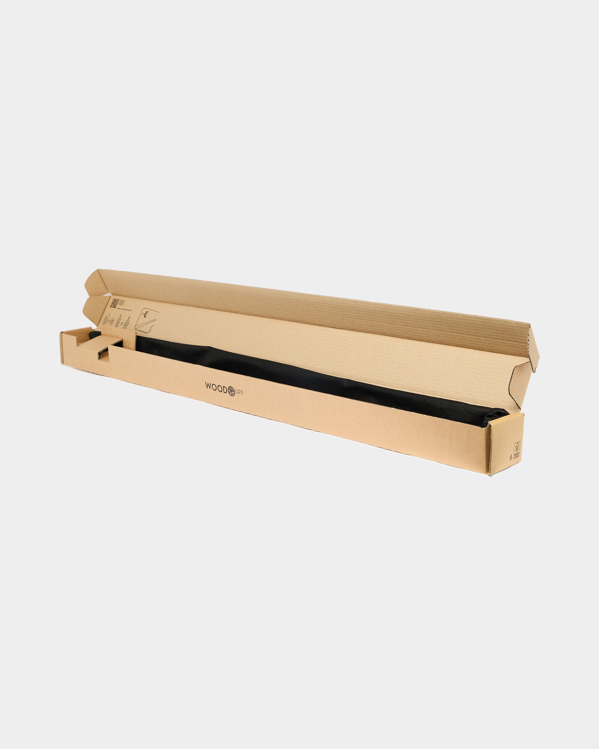 An open long cardboard box on a white background reveals a sleek black acoustic panel inside; the box has minimal branding for a Nordic, minimalist appearance.