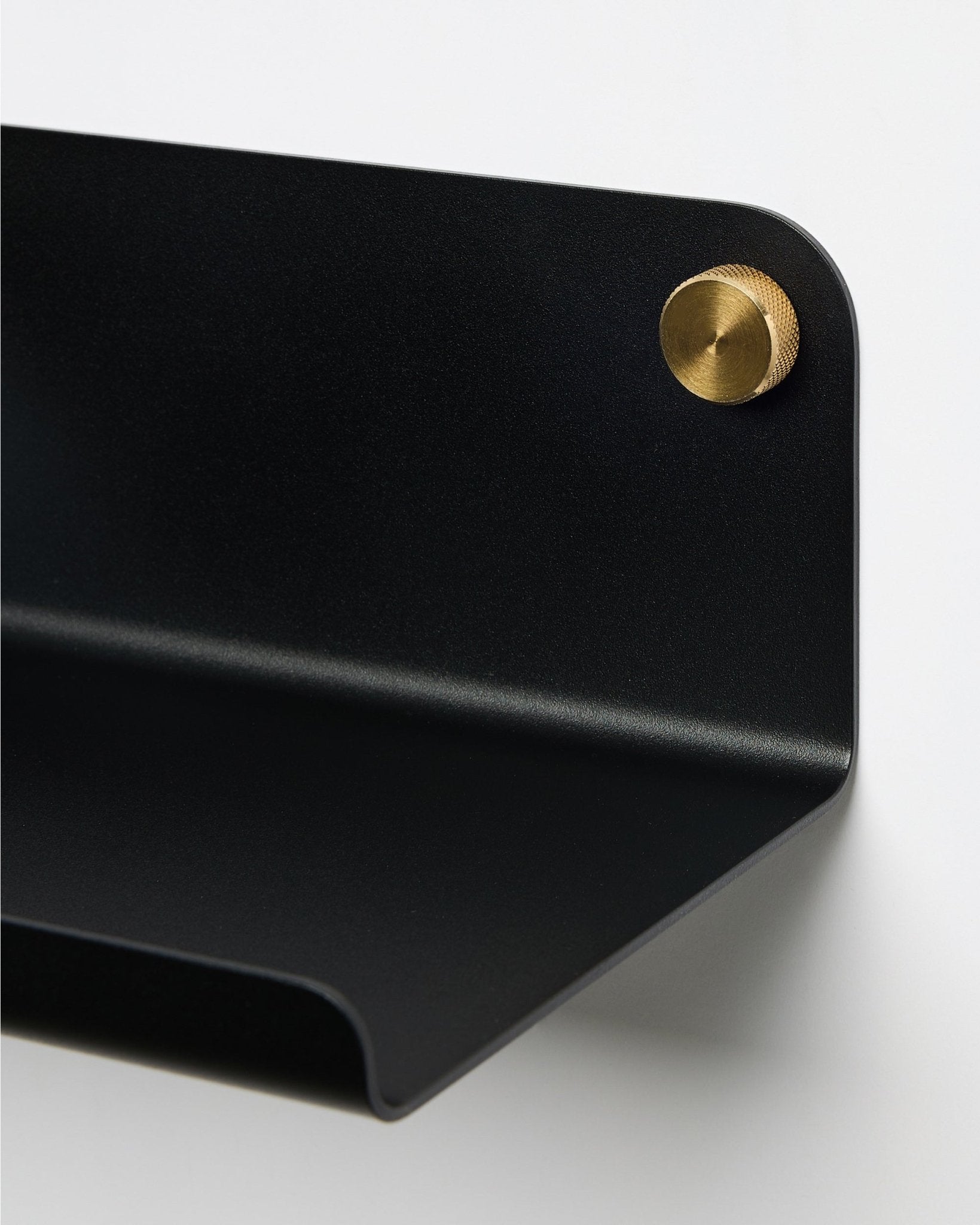 Gros plan sur l’étagère large WoodUpp Norr en black, 35,9 cm, avec un bord incurvé, fixée au mur à l’aide d’une vis ronde brass. Design nordique minimaliste.