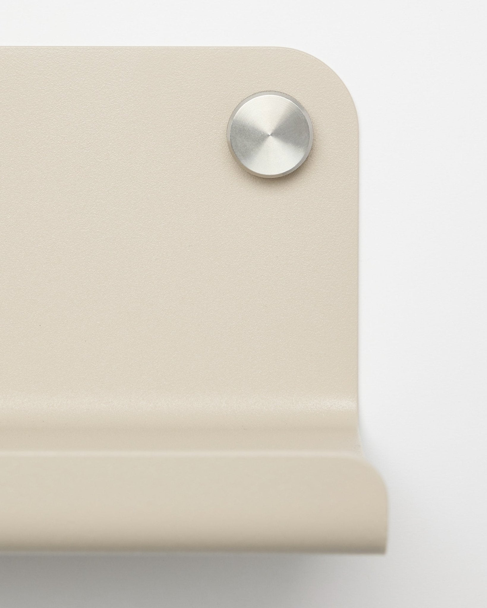 Gros plan sur une équerre d’angle en métal beige avec une vis ronde argentée, conçue pour l’étagère large WoodUpp Norr, 35,9 cm, sur fond blanc.