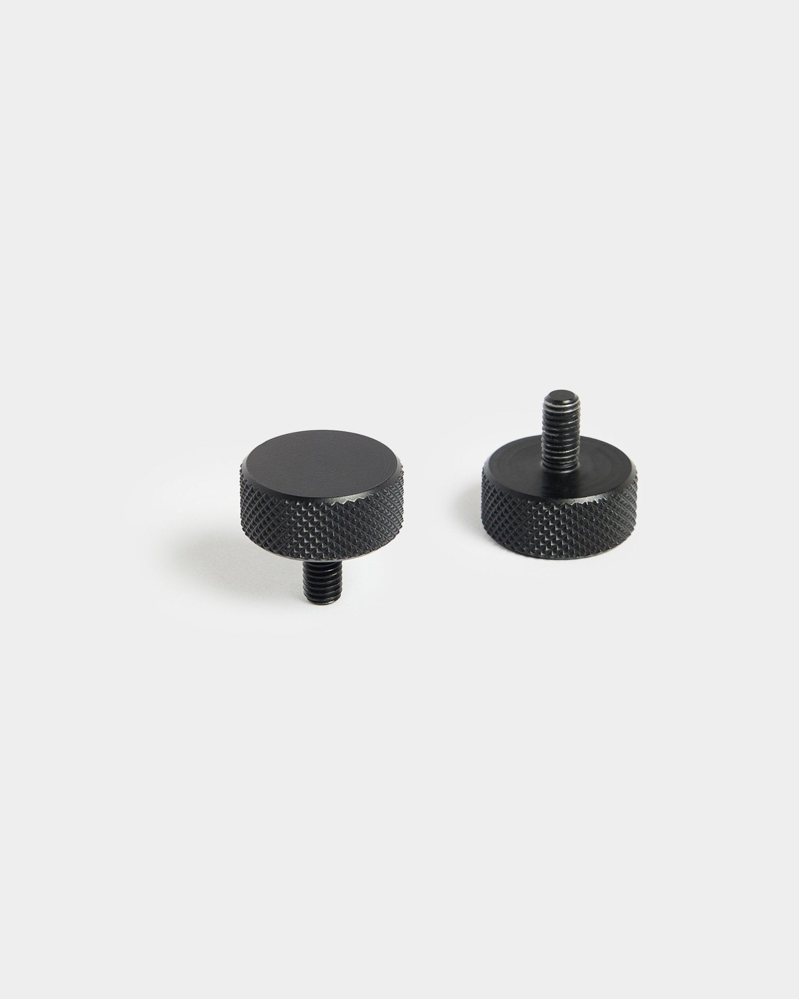 Paire de vis WoodUpp Finger black (M5x10 mm, 20x8.8) avec bords moletés, conçues pour être utilisées avec les accessoires Panneau acoustique, sur fond blanc uni.