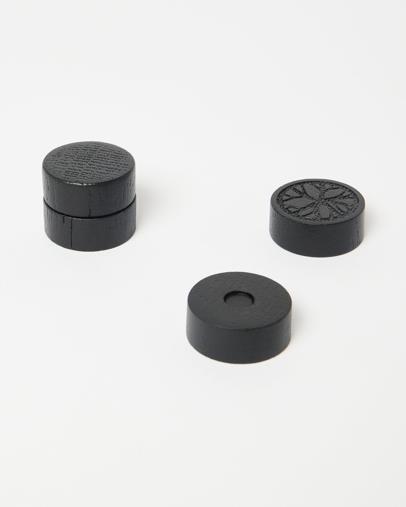 Lot de quatre aimants black oak Norr de WoodUpp, faisant partie de la collection d’accessoires CREATE, soigneusement disposés sur une surface blanche épurée.
