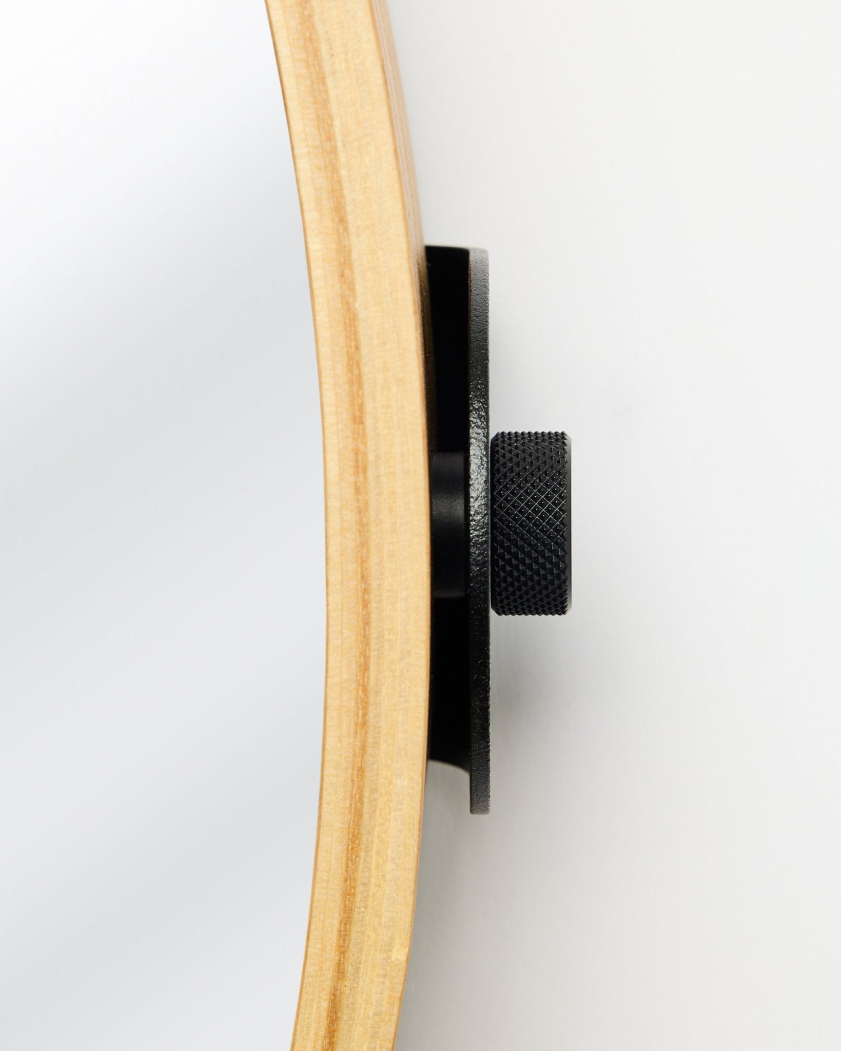 Vue latérale en gros plan du Linn | Mirror de WoodUpp en Natural Oak, avec un cadre rond en chêne et un bouton métallique black, accessoire pour panneaux acoustiques en bois.