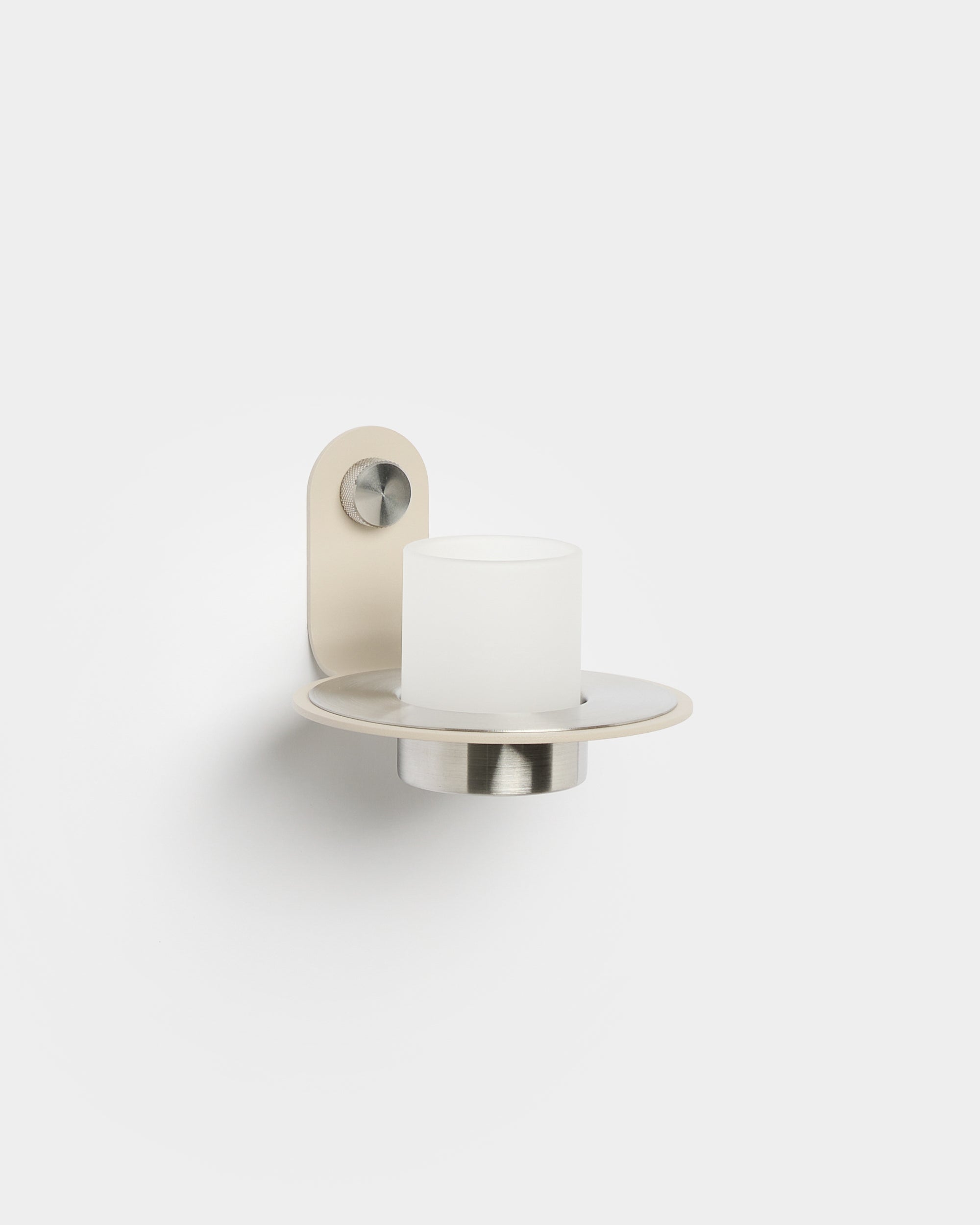 Le bougeoir Norr de WoodUpp, avec une base en acier inoxydable beige steel, est posé sur un Akupanel Panneau acoustique pour une touche nordique moderne.