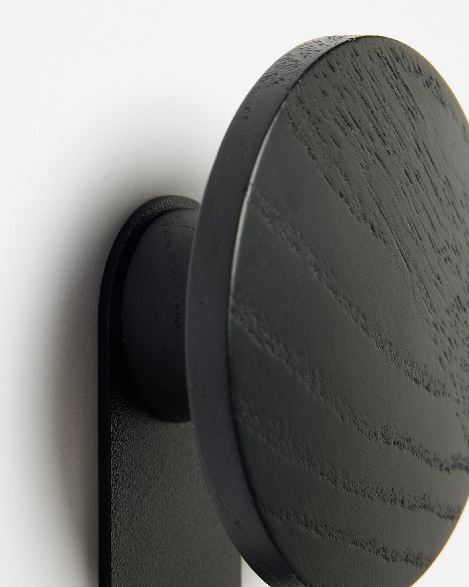 Gros plan sur le Hanger WoodUpp Linn | Vertical en Black Oak, mettant en valeur le veinage détaillé du bois sur un fond blanc Akupanel Panneau acoustique.