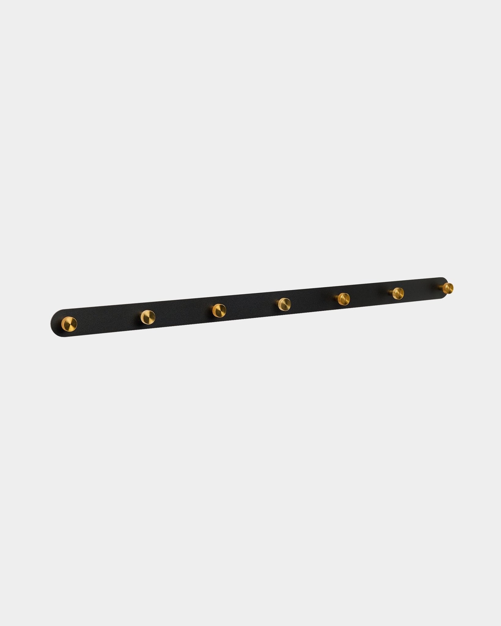 Le porte-manteau mural Norr de WoodUpp avec 7 crochets en brass sur une base black Panneau acoustique est conçu comme un organiseur de couloir compatible avec les collections Akupanel.