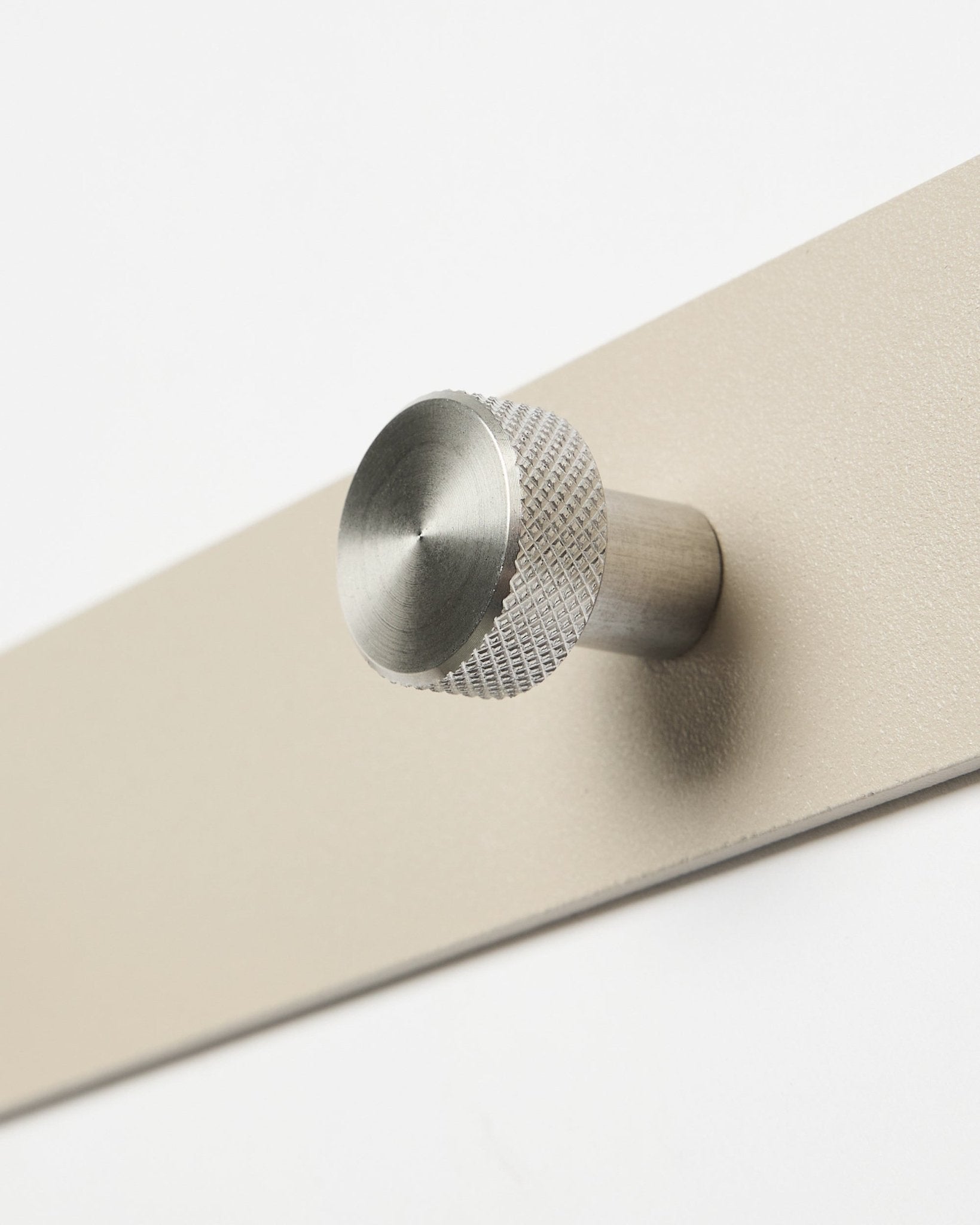 Porte-manteau mural Norr en beige et steel en acier inoxydable par WoodUpp, accessoire de la collection Akupanel, présenté en gros plan sur fond blanc.