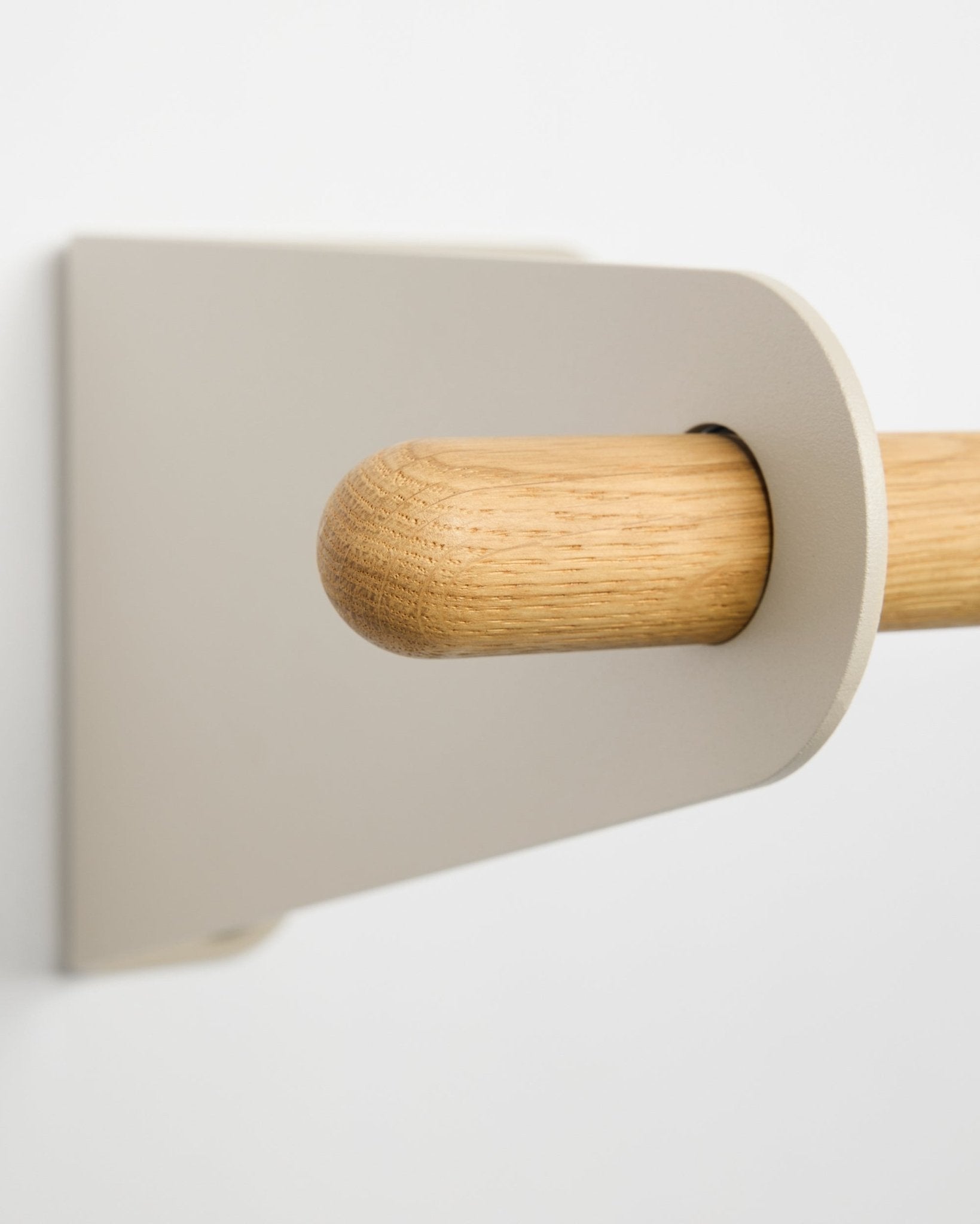 Gros plan sur le portemanteau WoodUpp Linn en beige (75,9 cm), une barre en chêne massif avec support minimaliste, fixé au mur blanc, qui illustre le design nordique.