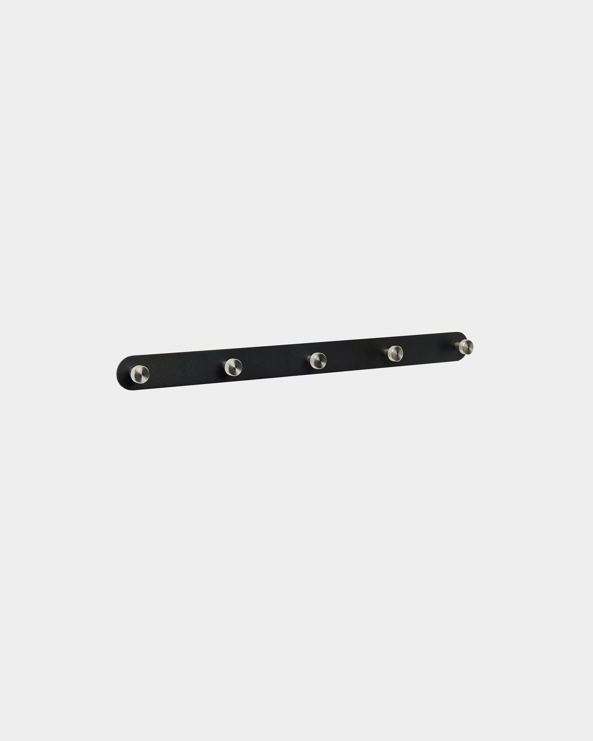 Porte-manteau mural WoodUpp Norr X5 en black et acier inoxydable steel, avec cinq crochets régulièrement espacés, fixé sur un fond blanc uni. Design nordique minimaliste.