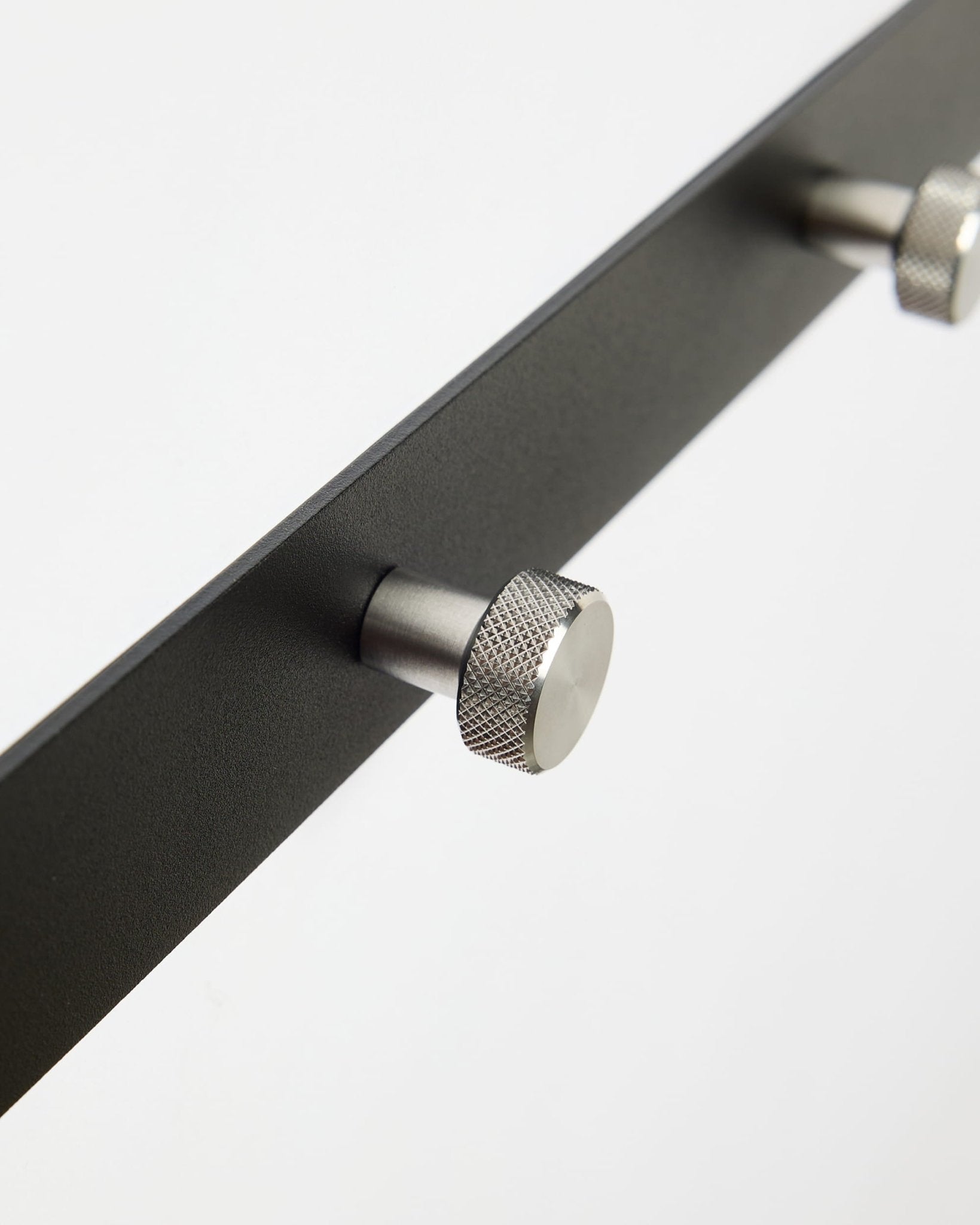 Gros plan sur Norr | Coat Hook Rack / X5 de WoodUpp en black et acier inoxydable steel, conçu comme accessoire pour les panneaux acoustiques Akupanel ou pour une entrée.