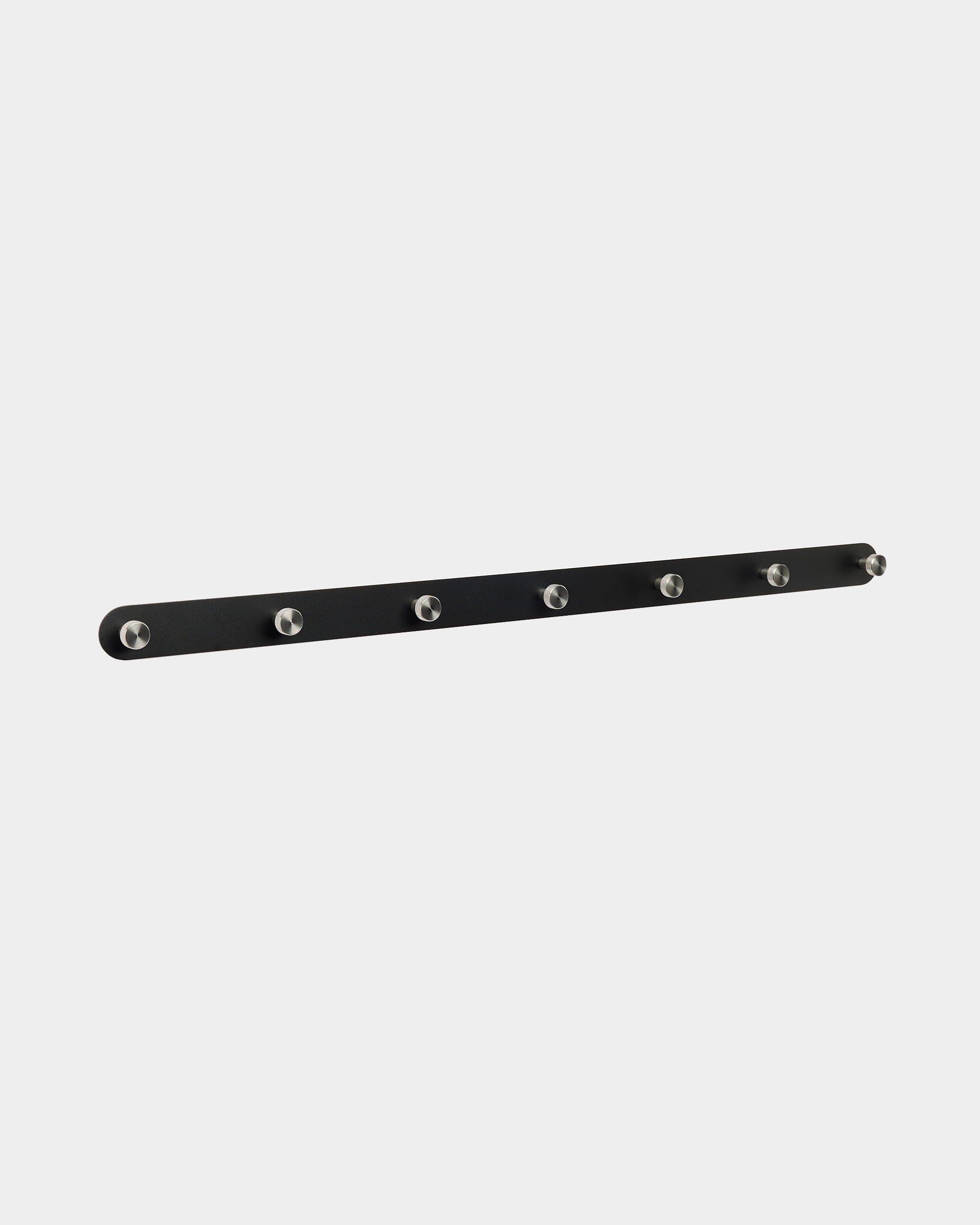 Le porte-manteau mural WoodUpp Norr présente un design nordique en black, avec 7 crochets argentés, pensé pour compléter les panneaux acoustiques Akupanel dans une entrée ou un couloir.