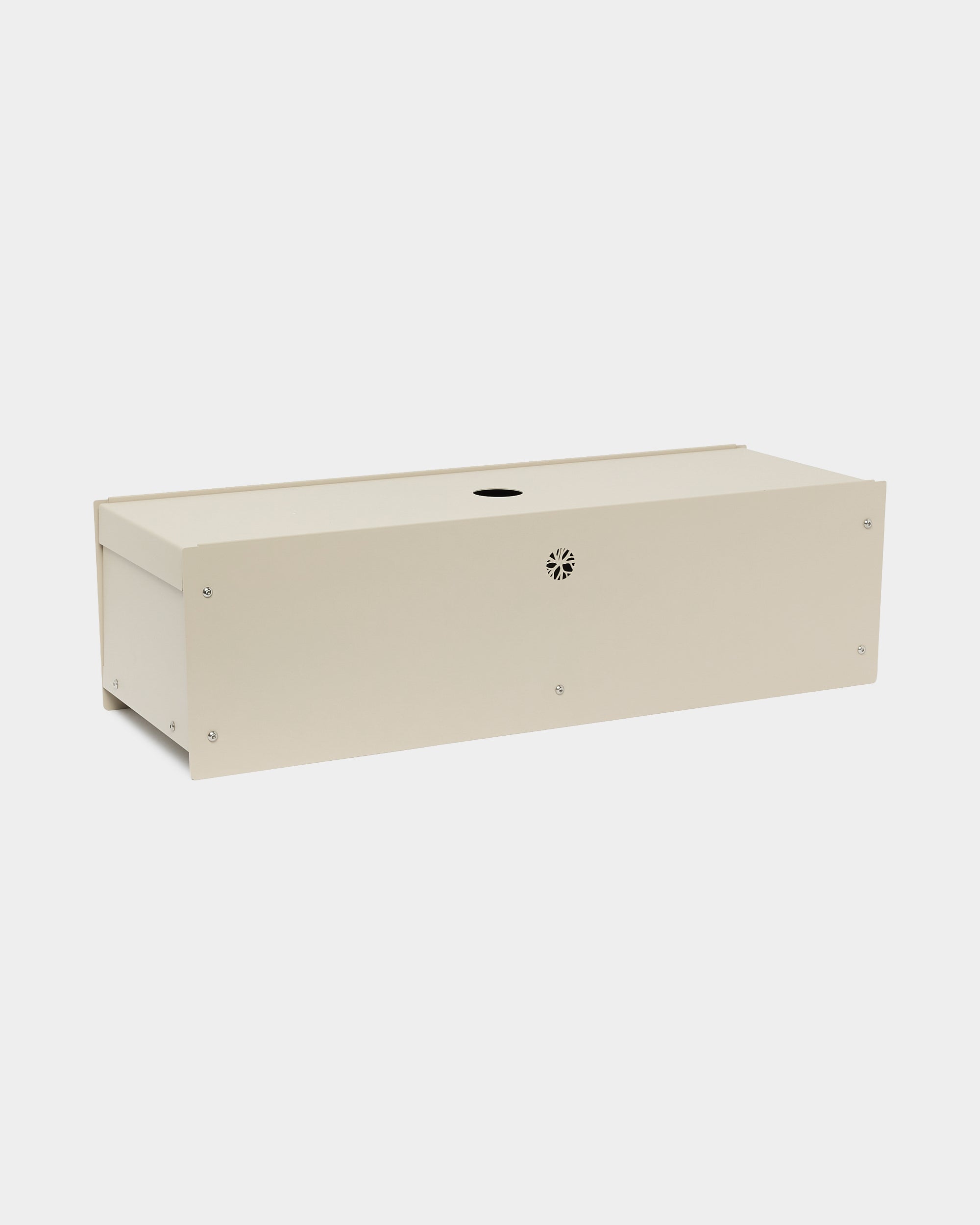 The Nell | Metal Box / BM2 de WoodUpp, une boîte rectangulaire en steel thermolaqué en beige, avec une ouverture circulaire et une fente d’aération, accessoire pour Akupanel, sur fond blanc.