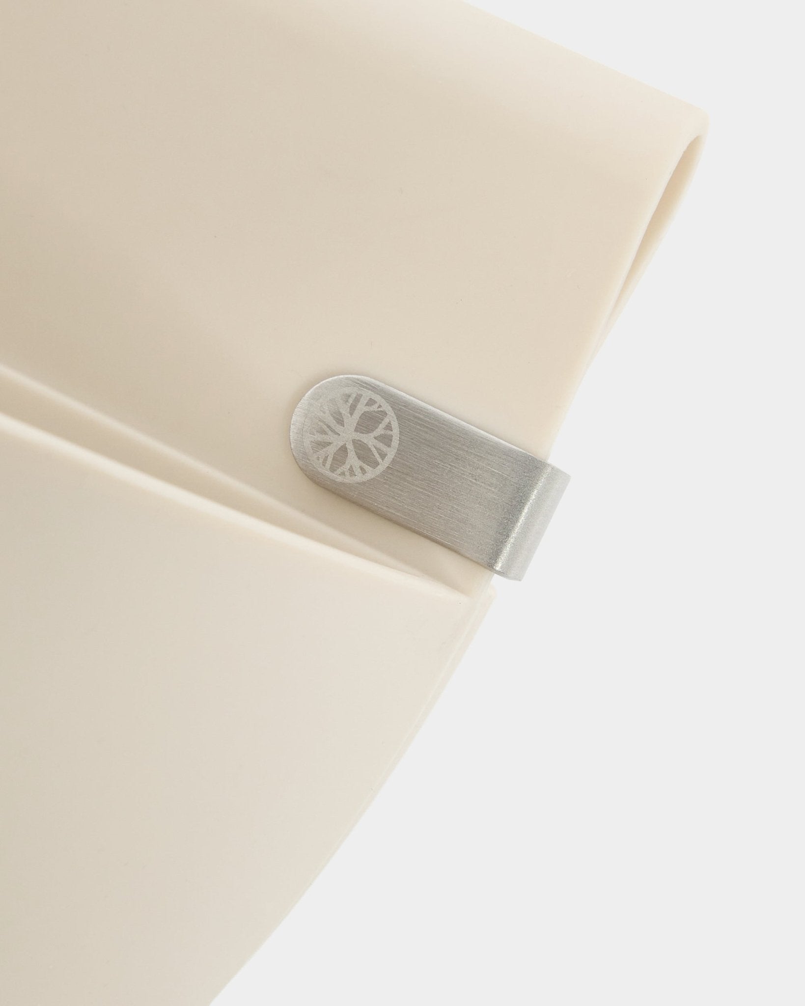 Gros plan sur un panneau WoodUpp Gro | Soft Pocket / BM2 (4 l) en beige clair, avec clip métallique et détail circulaire gravé, sur fond blanc uni.