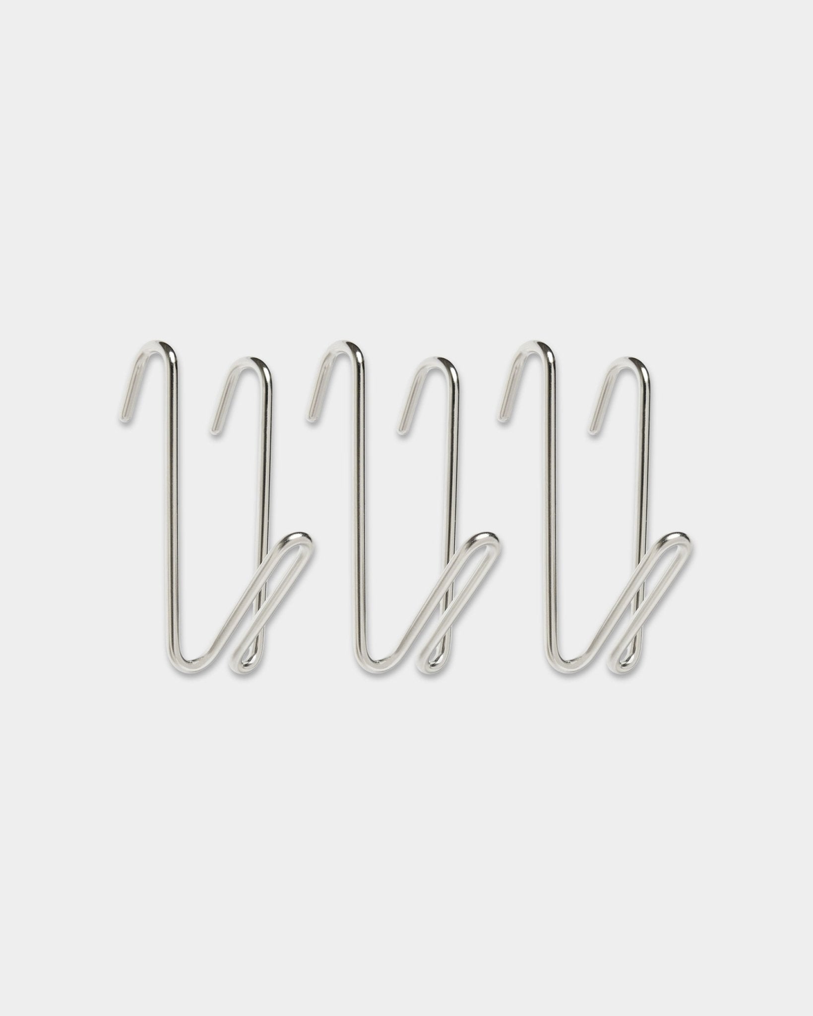 Trois crochets Alva Wire Hook / BM1, en acier inoxydable steel, format court de la collection CREATE de WoodUpp, au design en boucle, alignés sur une rangée sur fond blanc uni.