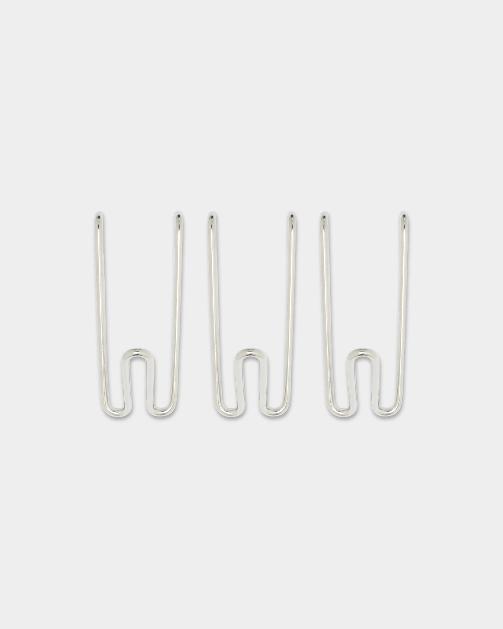 Trois Alva Wire Hooks BM1, format court, en acier inoxydable steel de la collection CREATE de WoodUpp, espacés de façon régulière sur un fond blanc uni.
