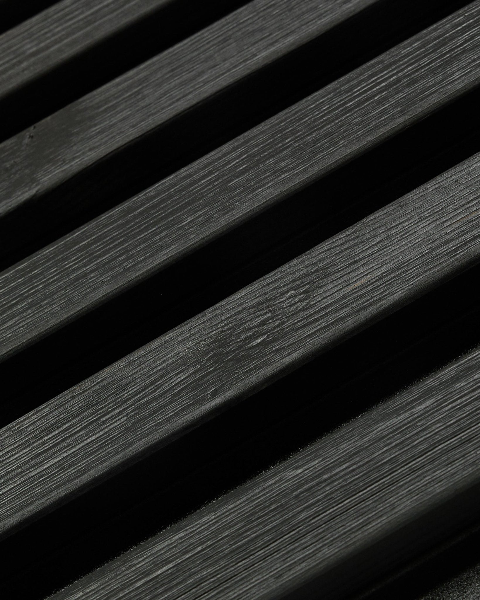 Panneau de façade extérieur Aluwood de WoodUpp, en Thermowood avec finition black, 240 x 45,1 cm, avec des lattes diagonales en épicéa nordique au veinage et aux jeux d’ombre visibles.