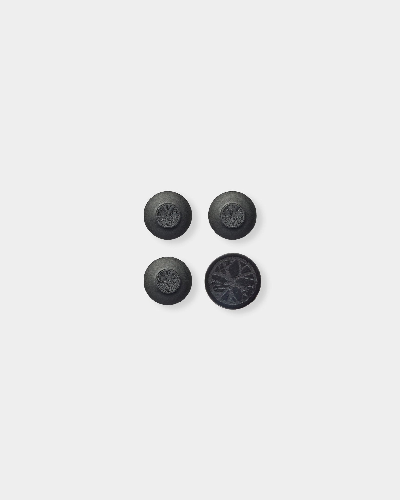 Trois black Dupps ronds et une pièce circulaire arborant un motif détaillé de lattes acoustiques en bois inspiré de Nordic WoodUpp Akupanel, sur un fond gris clair.