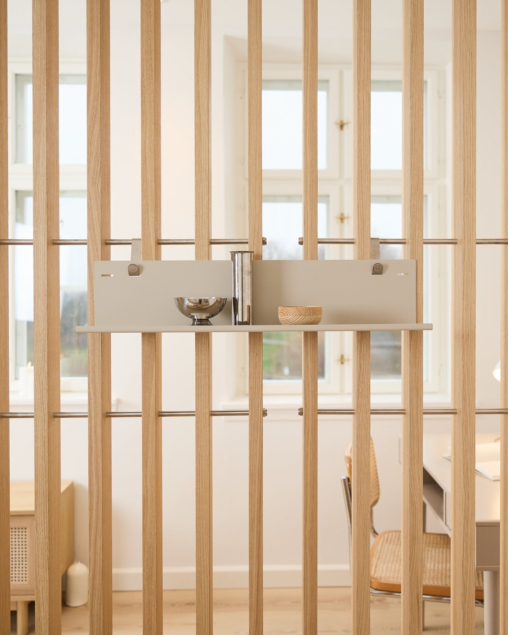 L’étagère en métal WoodUpp beige BM1 (63 x 13,4 cm) accueille un bol, une tasse et un cylindre haut, fixée sur des panneaux acoustiques à lattes en bois vertical dans une pièce lumineuse.