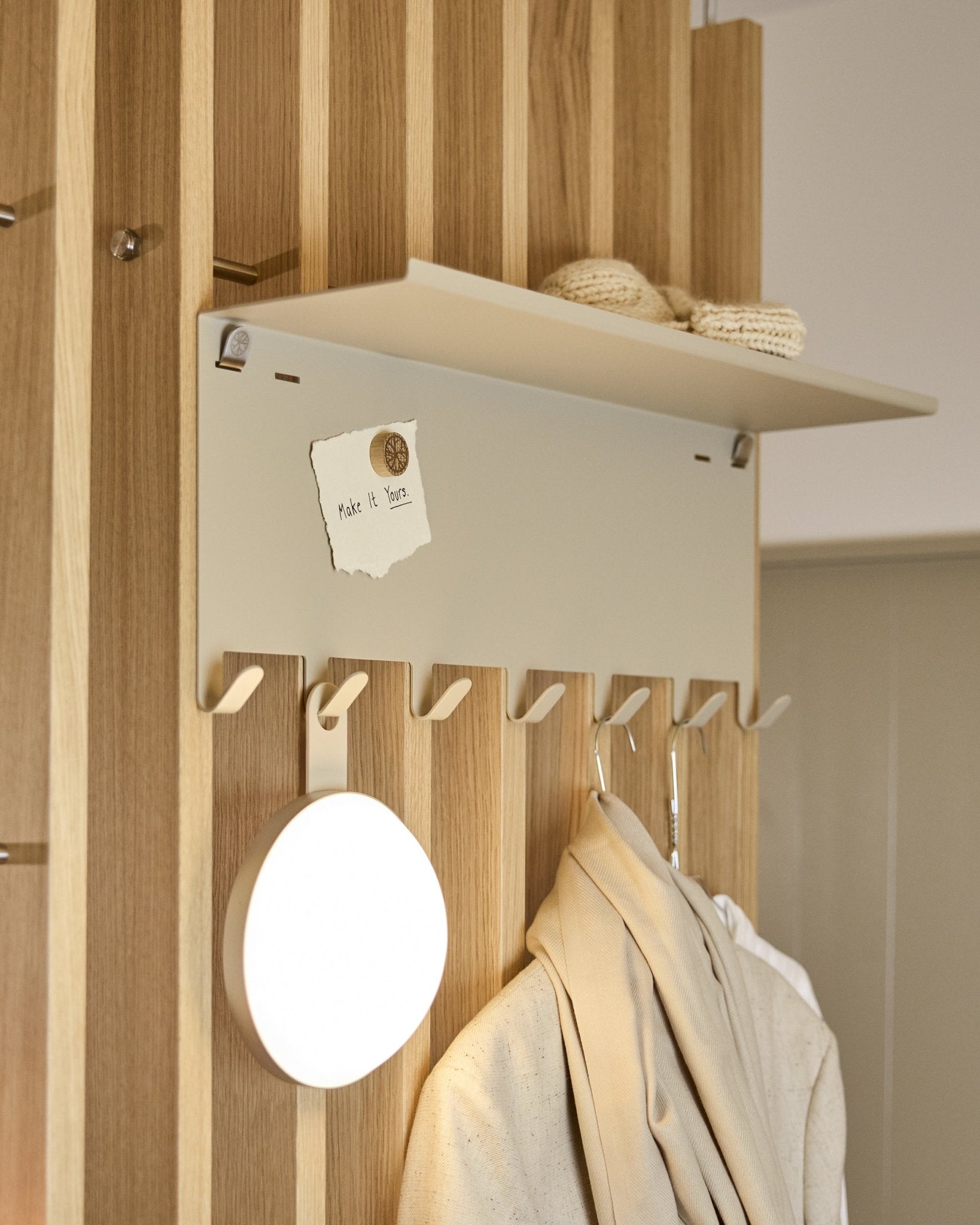 WoodUpp Nell | porte-manteau BM1 en beige (63,5 x 24 cm), avec steel crochets et une tablette accueillant des pièces en maille ainsi qu’une note portant le mot embrace BM1.